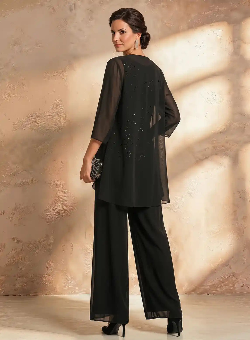 Back view of a black chiffon jacket pantsuit with an elegant flowing silhouette