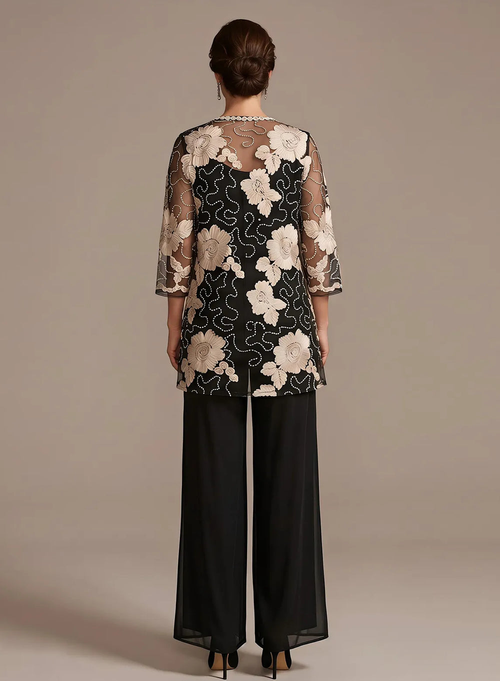 Back view of a black pant suit featuring an elegant floral lace jacket for formal occasions