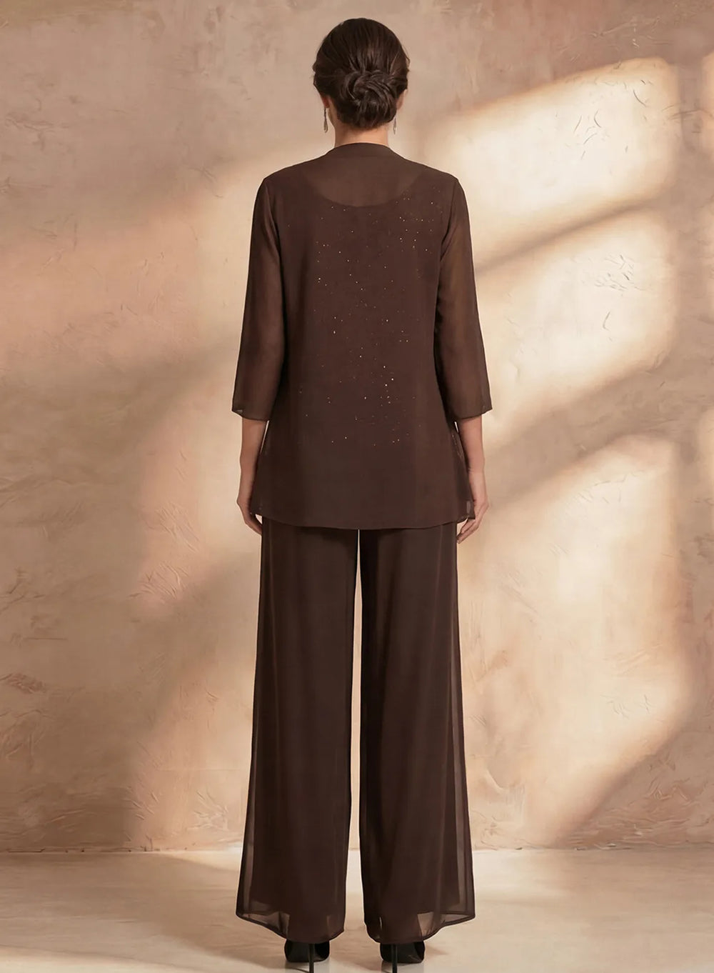 Back view of brown formal pant suit with flowing chiffon pants and elegant evening jacket
