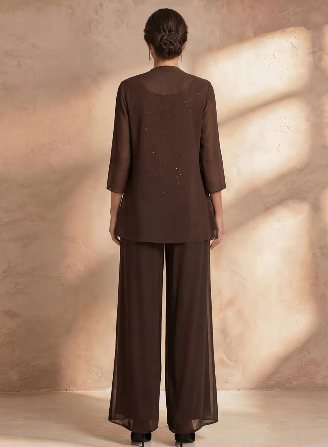 Back view of brown formal pant suit with flowing chiffon pants and elegant evening jacket
