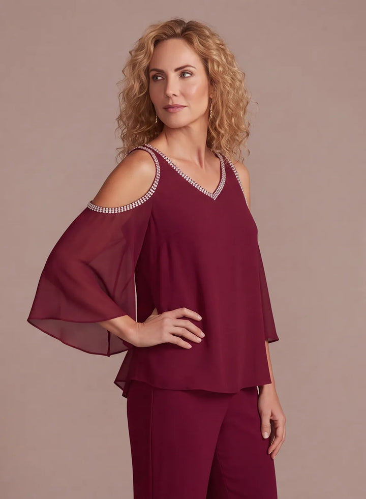 Detail of flowing burgundy chiffon overlay top with cold shoulder sleeves