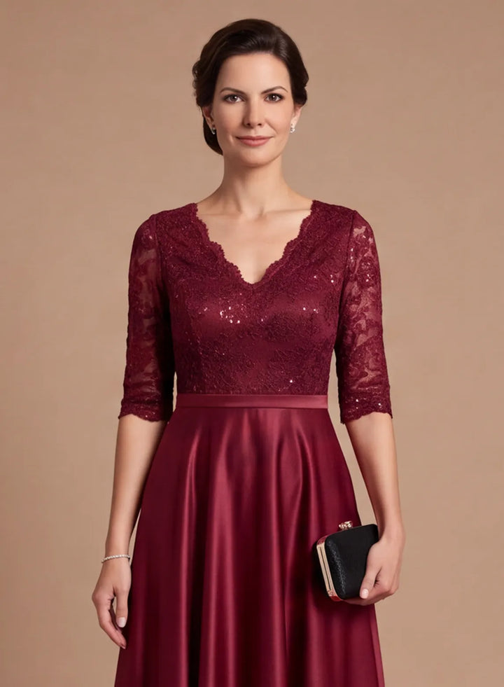 Close-up of burgundy lace bodice with V-neckline and 3/4 sleeves on a satin formal gown