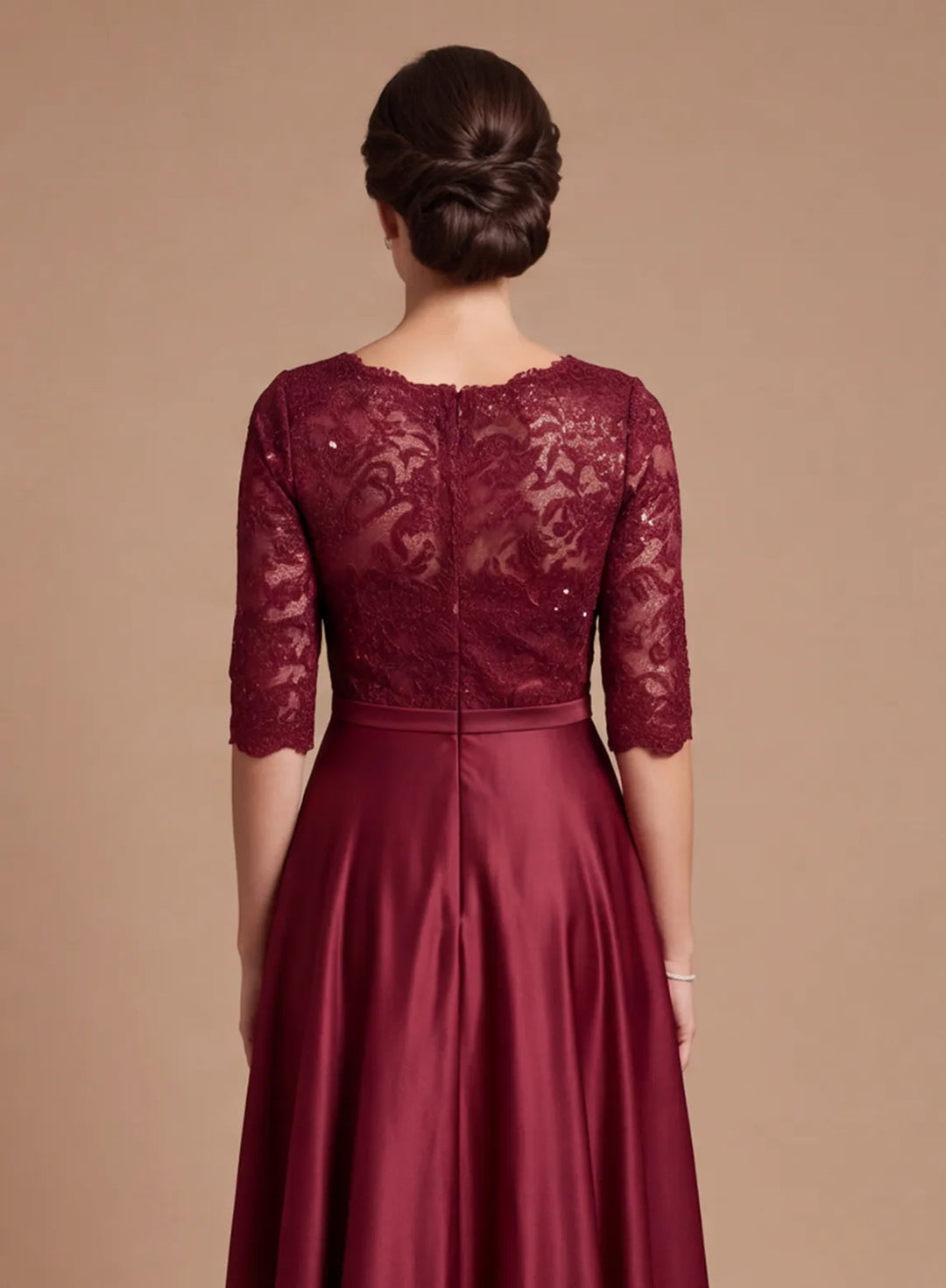 Back detail of burgundy lace bodice with intricate floral lace pattern and flowing satin skirt