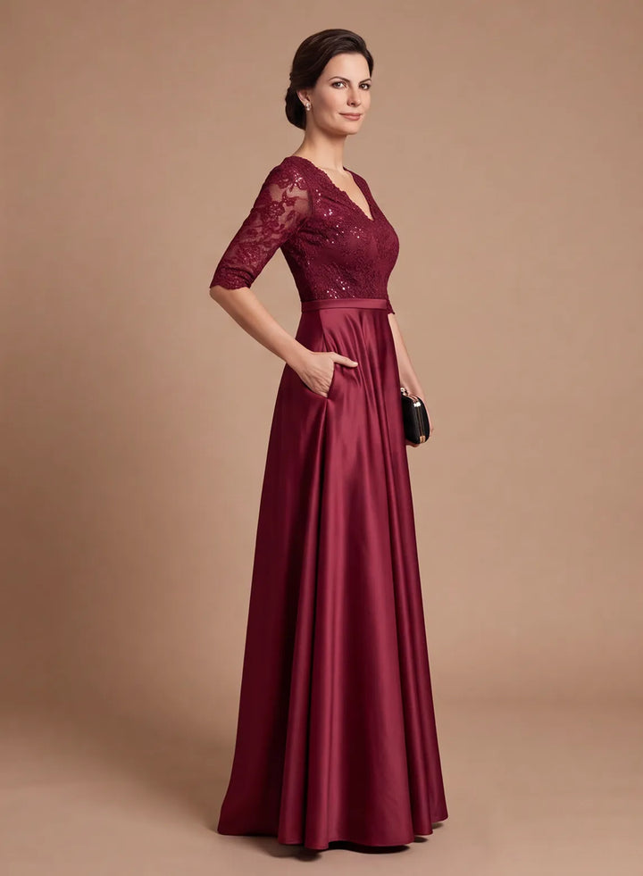 Side view of elegant burgundy mother of the bride dress featuring a lace bodice and lustrous satin A-line skirt