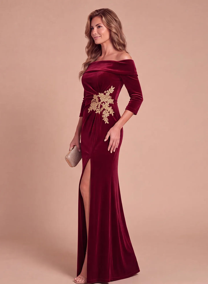 Side view of a burgundy velvet formal gown featuring an off-the-shoulder neckline, gold floral waist detail, and fitted silhouette.