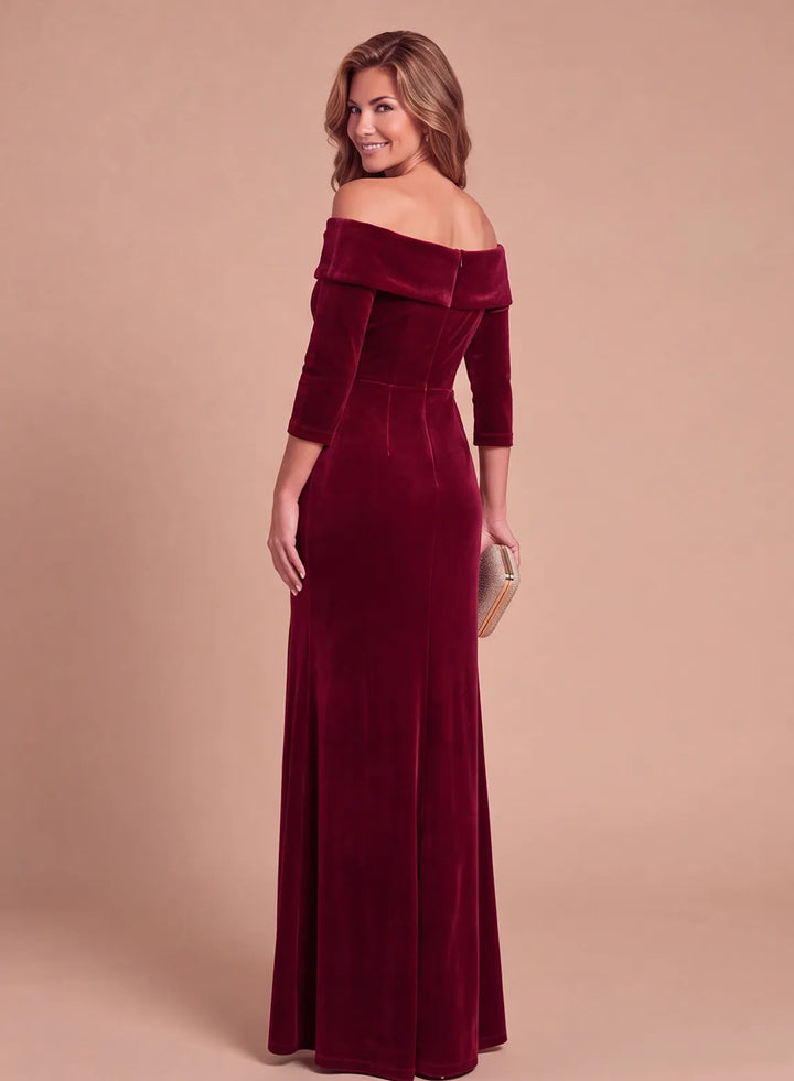 Back view of a burgundy velvet off-the-shoulder evening gown with a fitted waist and floor-length skirt.