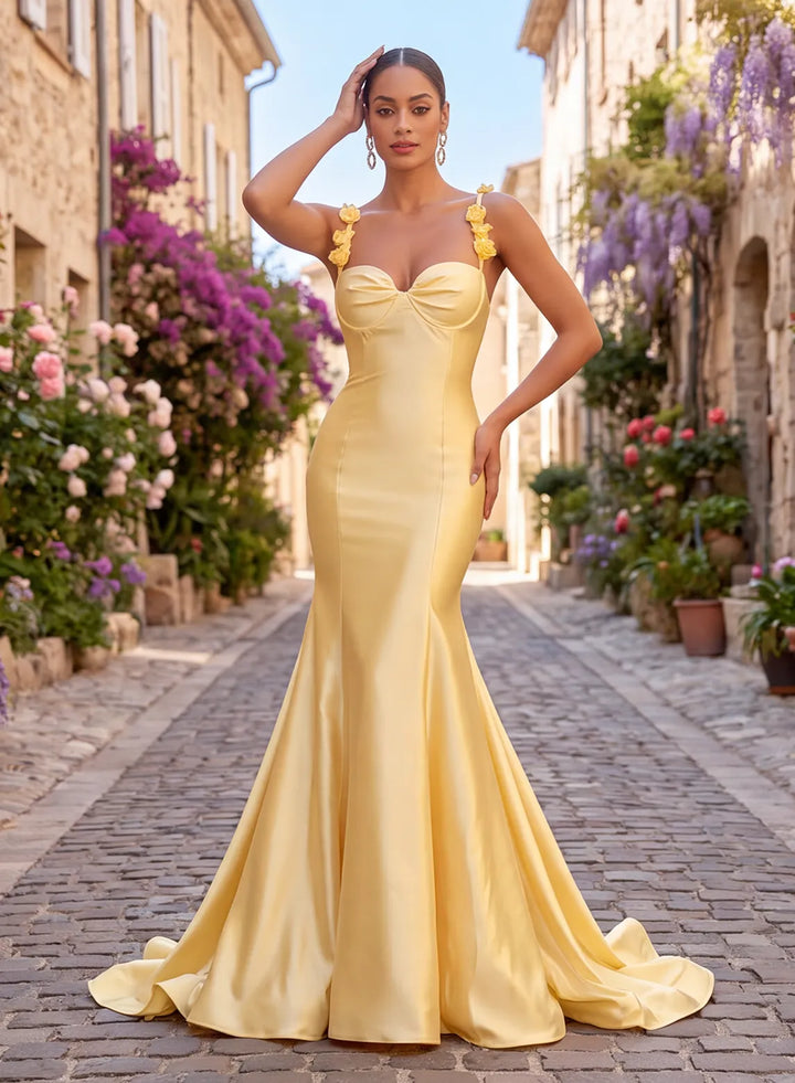 Butter yellow satin mermaid prom dress with floral shoulder straps and elegant train, front view.