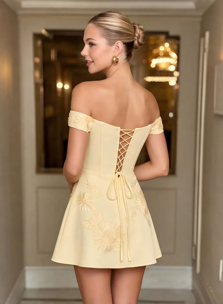 Champagne homecoming dress featuring an elegant lace up back and off shoulder design