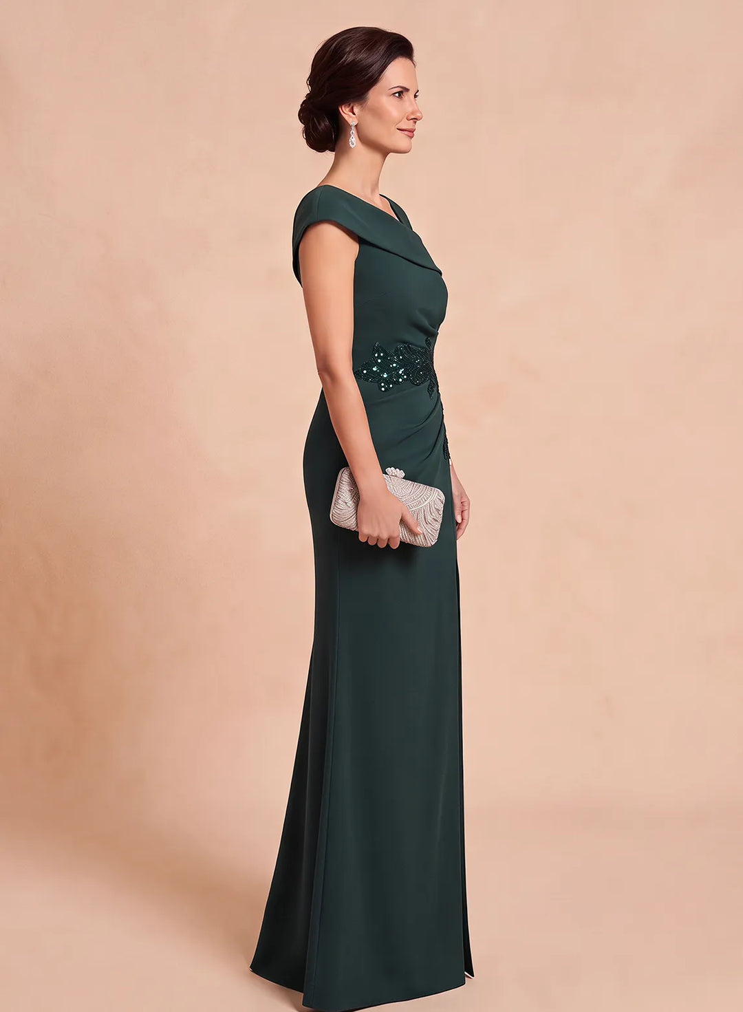Side view of an emerald green evening gown featuring a fitted silhouette and embellished waist