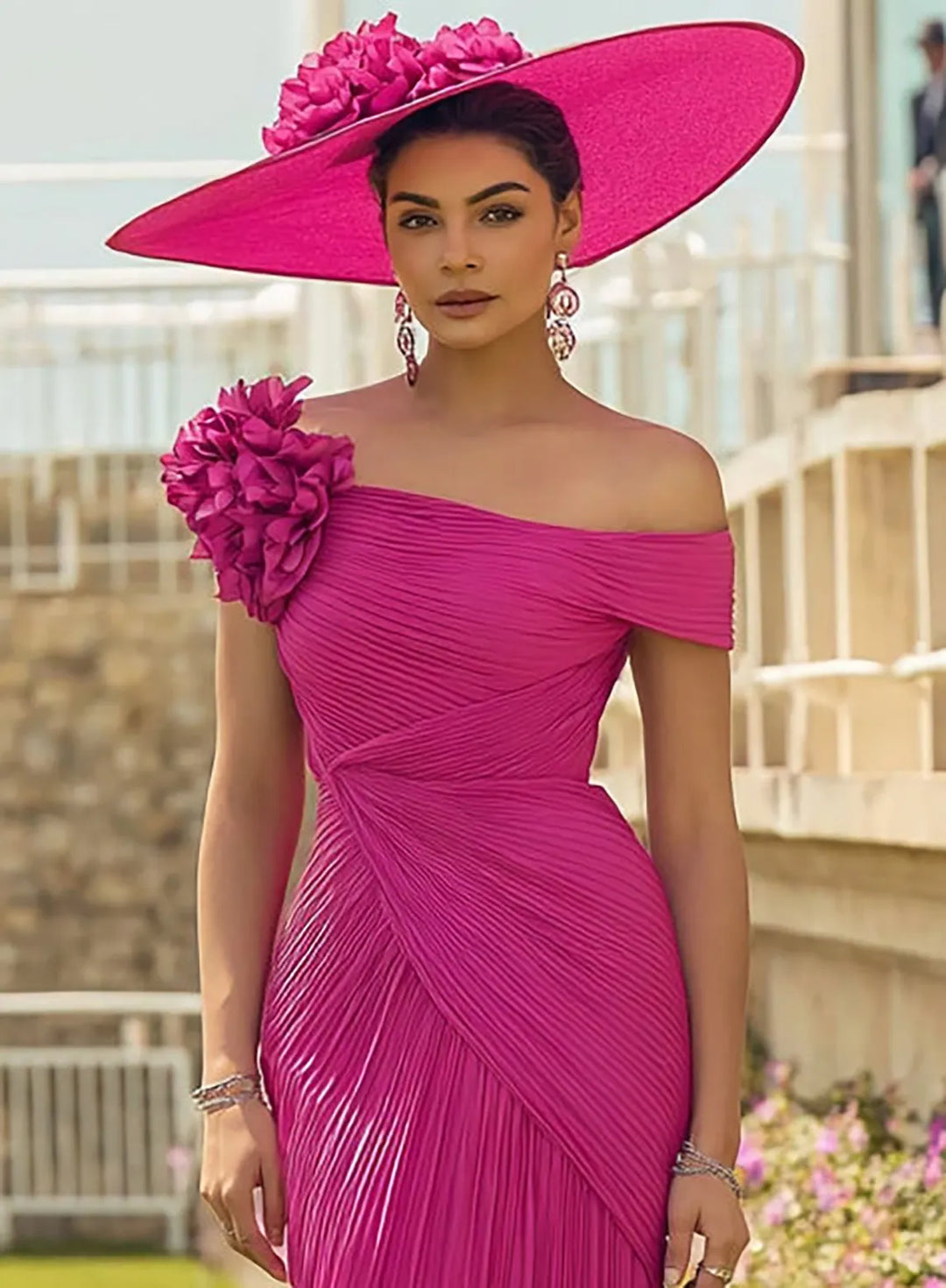 Fuchsia pink formal dress featuring a 3D floral shoulder detail and elegant draped design