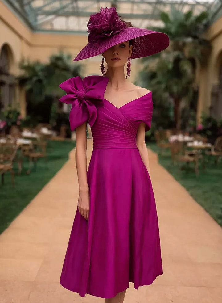 Fuchsia pink wedding guest midi dress with an off shoulder neckline and elegant feminine design
