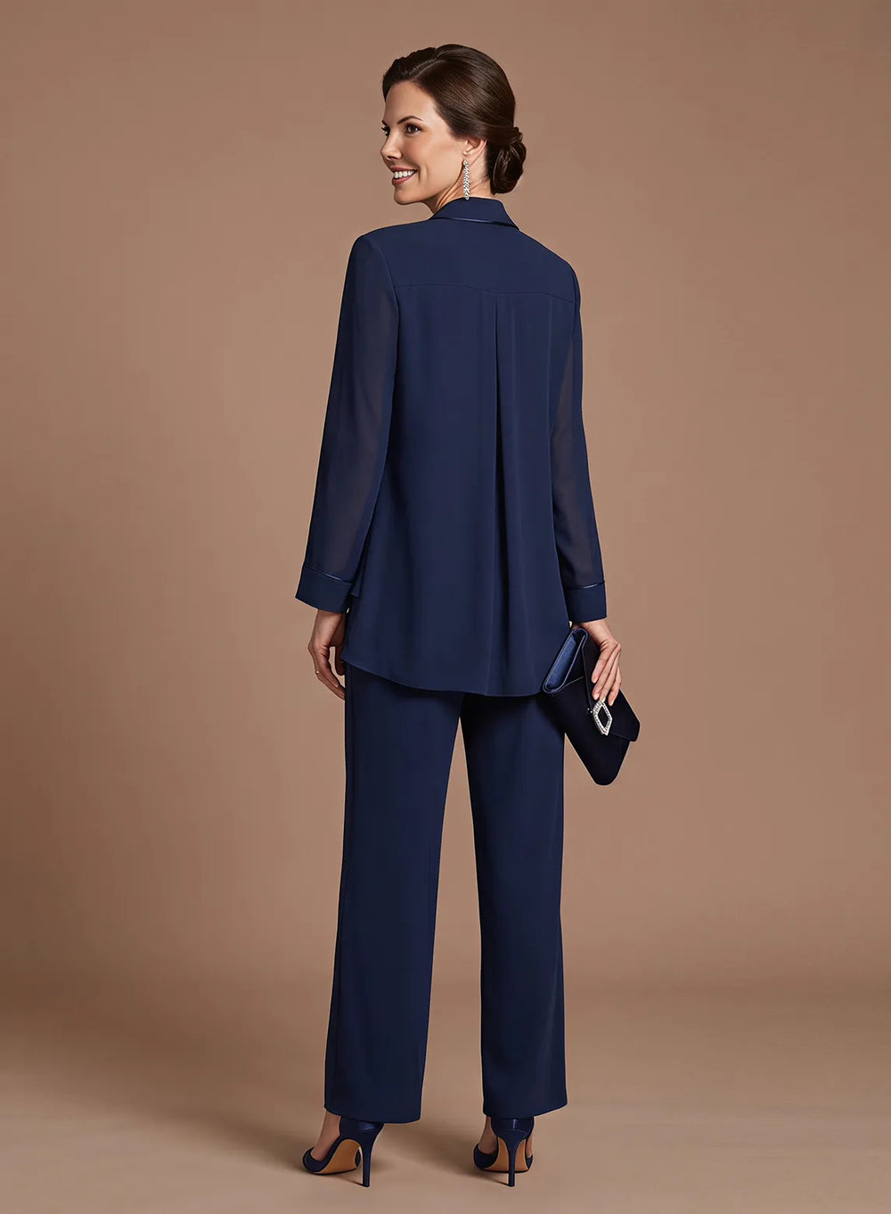 Back view of a women's navy 3-piece pantsuit featuring a flowing jacket and matching full-length trousers.
