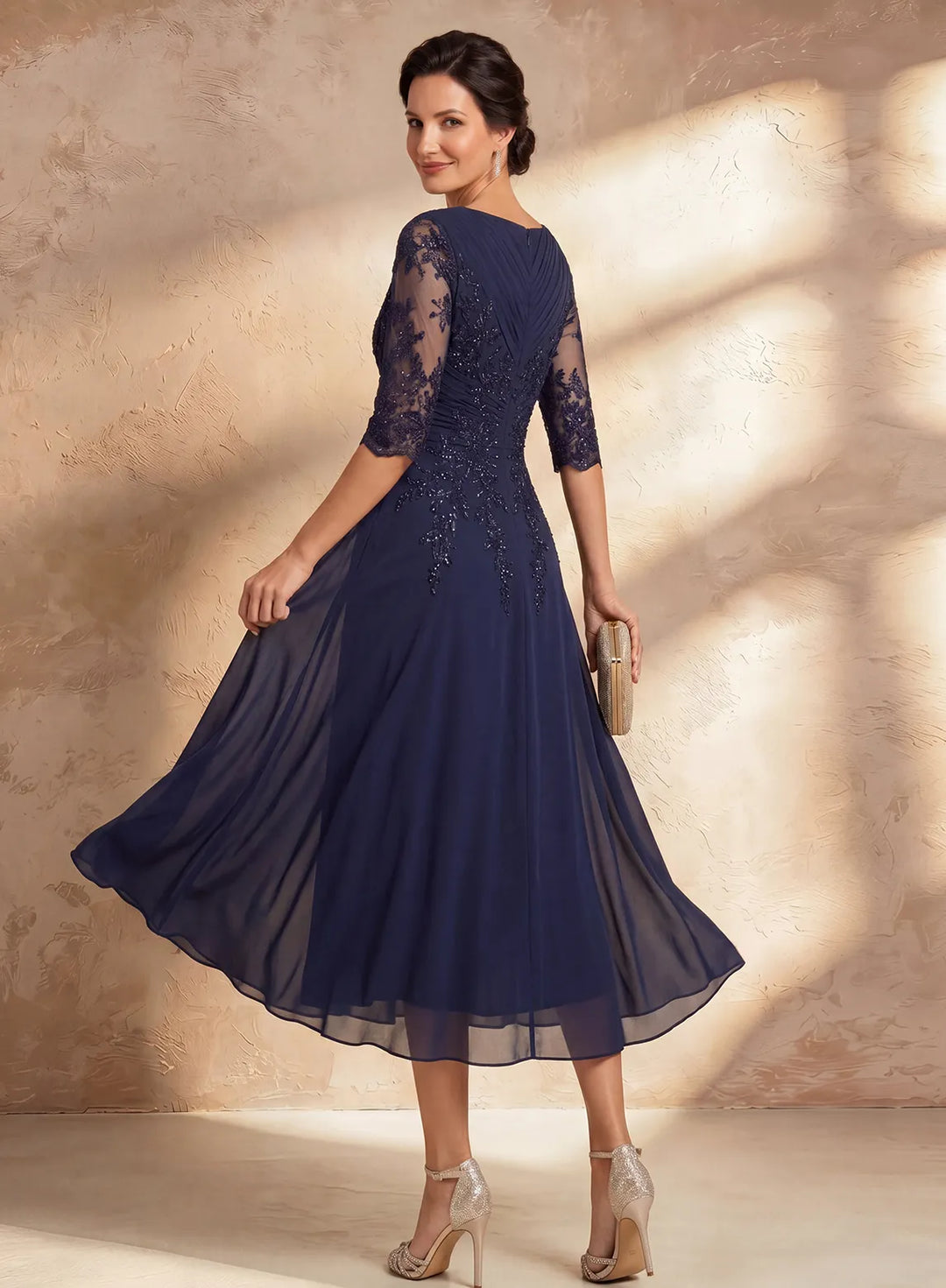 Back view of navy lace sleeve midi dress showing elegant wedding silhouette