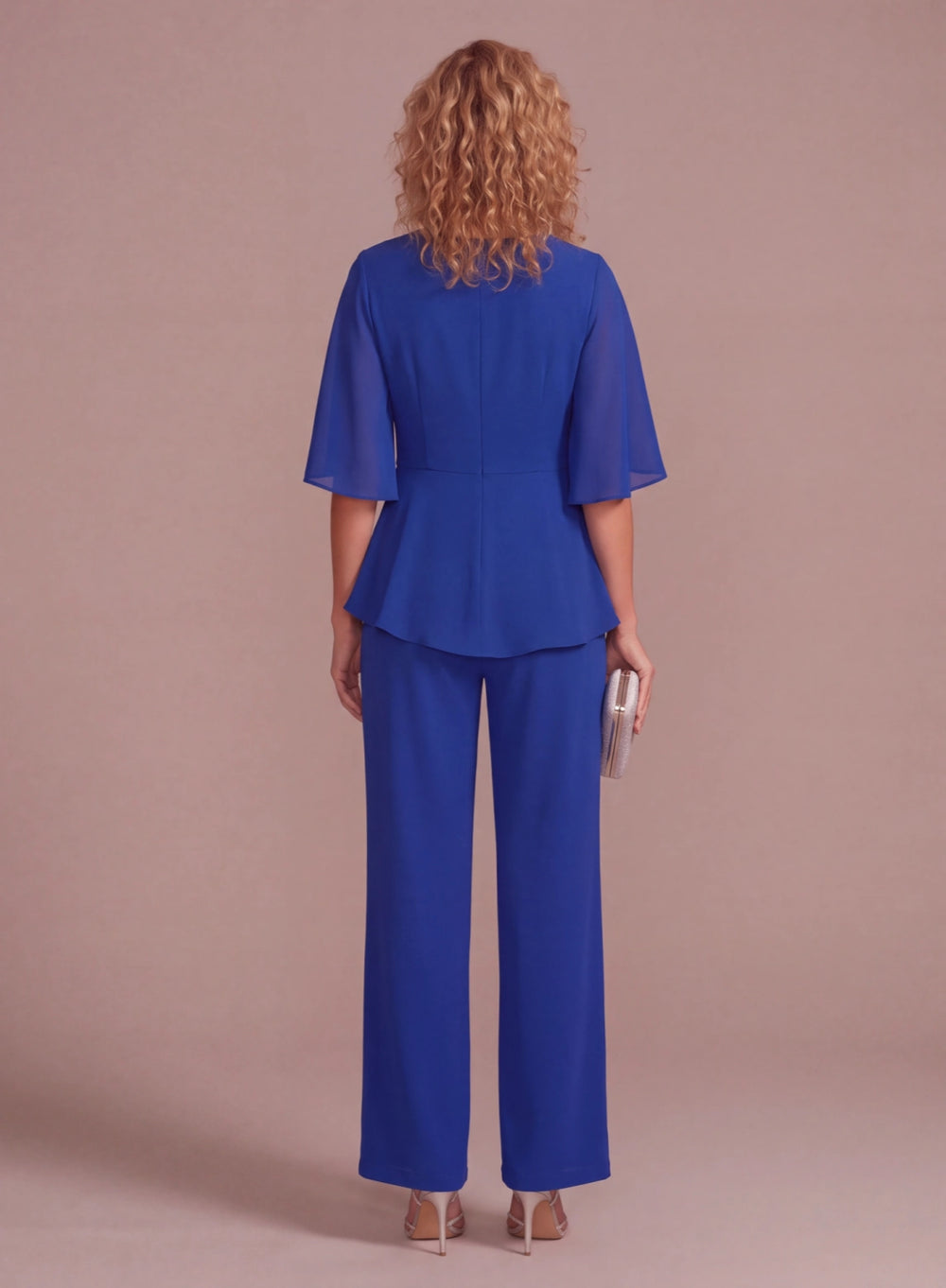 Back view of royal blue chiffon pantsuit with flowing cape sleeves and wide-leg pants