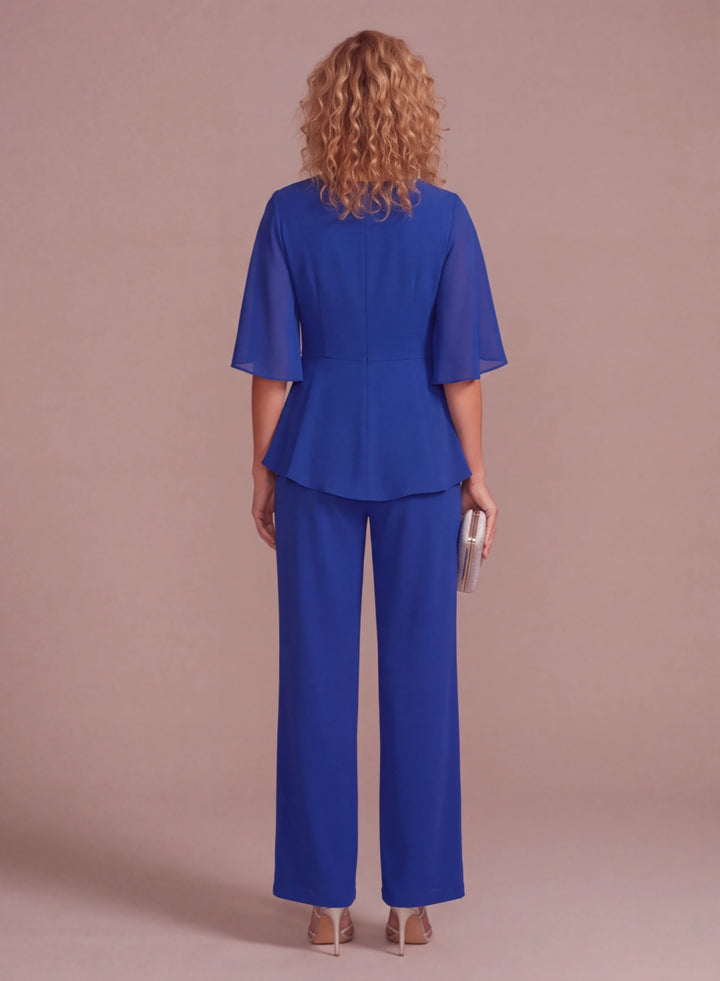 Back view of royal blue chiffon pantsuit with flowing cape sleeves and wide-leg pants