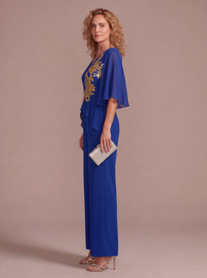 Side view of royal blue formal pantsuit with gold floral embroidery and flowing chiffon sleeves