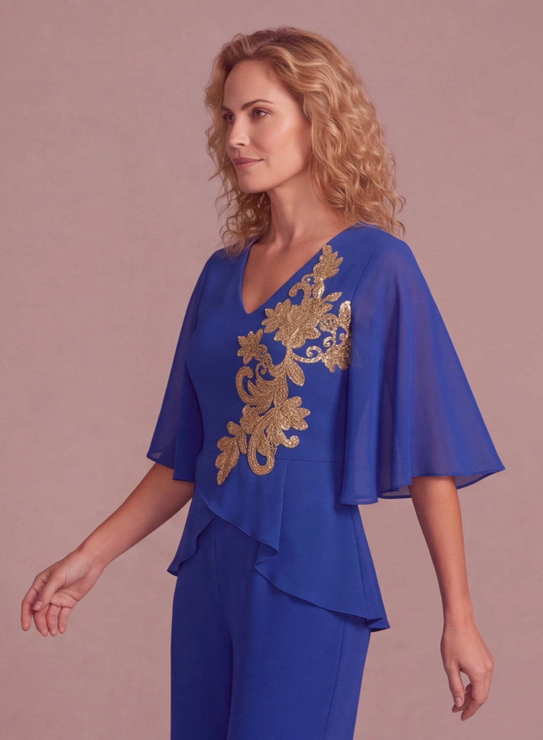 Side view of royal blue chiffon pantsuit featuring elegant cape sleeves and gold embroidery