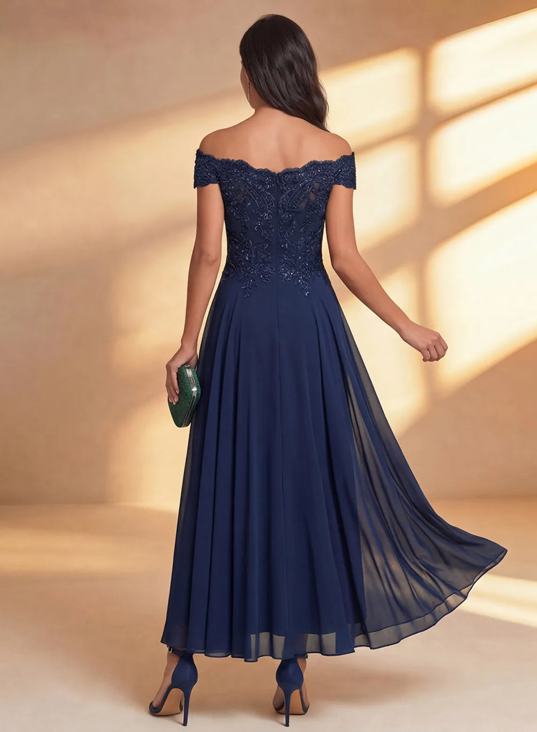 Back view of navy off shoulder wedding guest dress with flowing chiffon skirt